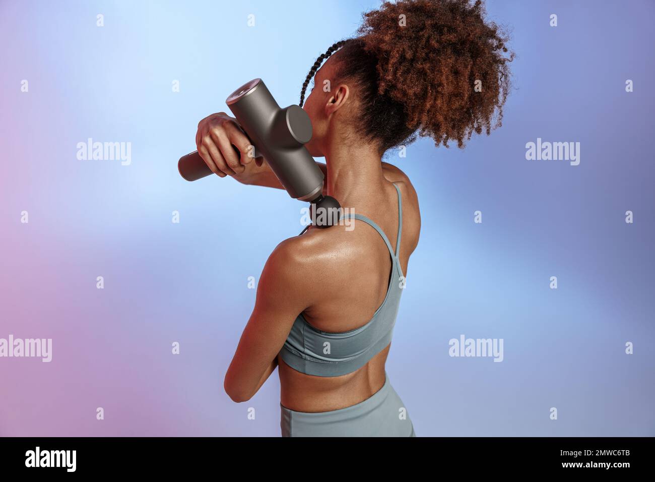 Woman use massage gun machine rehab after muscle workout standing on