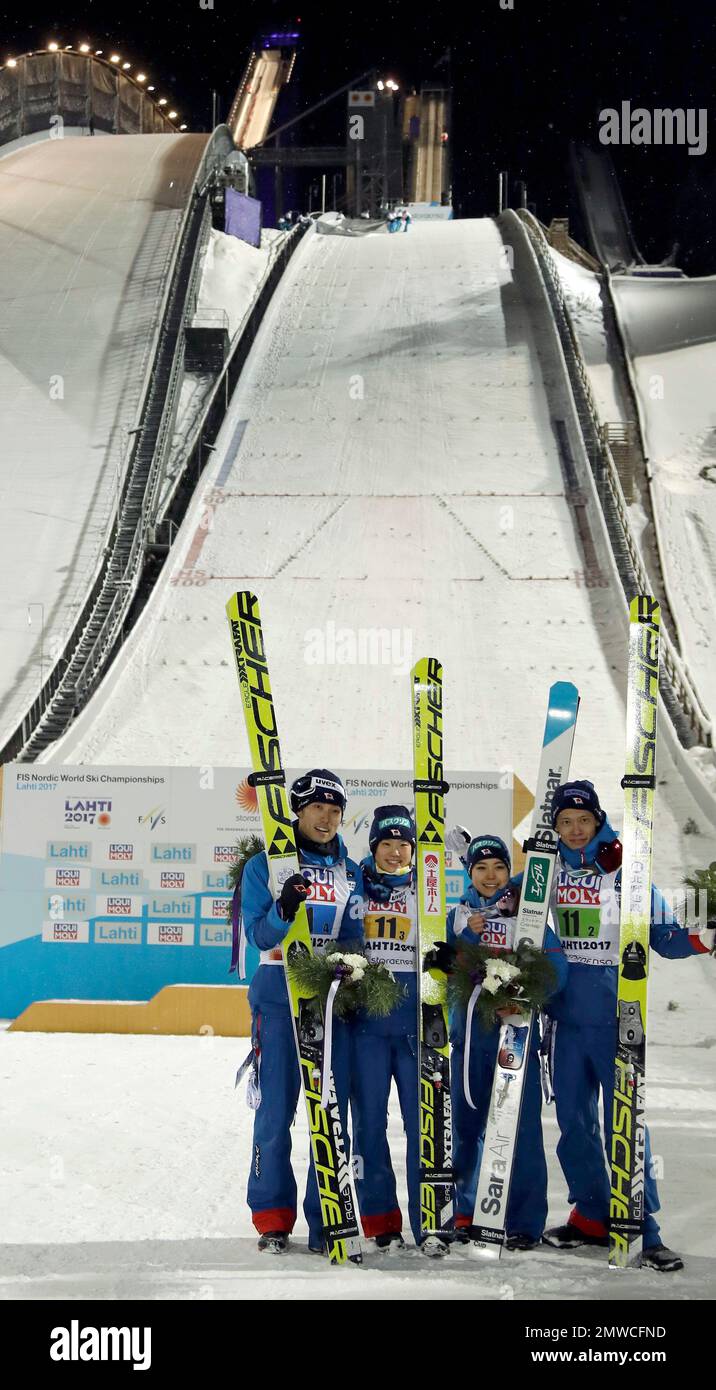From left, third placed Japan's Daiki Ito, Yuki Ito, Sara Takanshi and Taku  Takeuchi pose for the media after the flower ceremony for the mixed normal  hill ski jumping team competition at