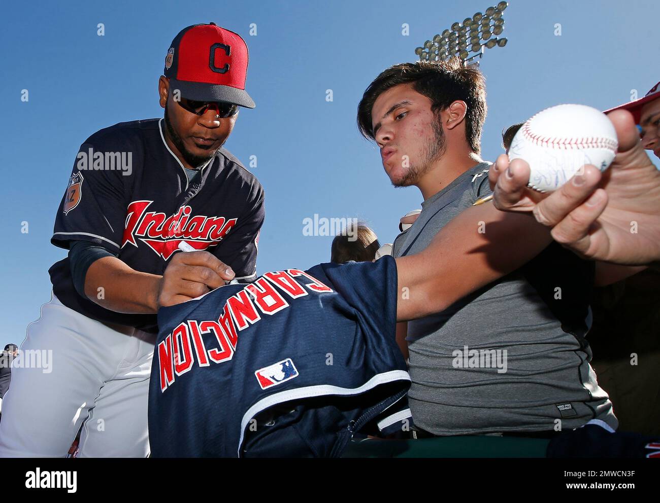 Cleveland Indians Edwin Encarnacion left gives autographs to fans prior to a spring training baseball game against the Cincinnati Reds Saturday Feb. 25 2017 in Goodyear Ariz. AP Photo Ross D. Franklin...