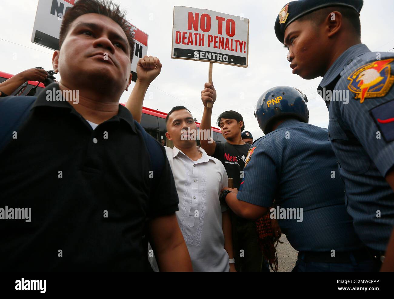 Police try to convince a placardbearing protester to move away as a