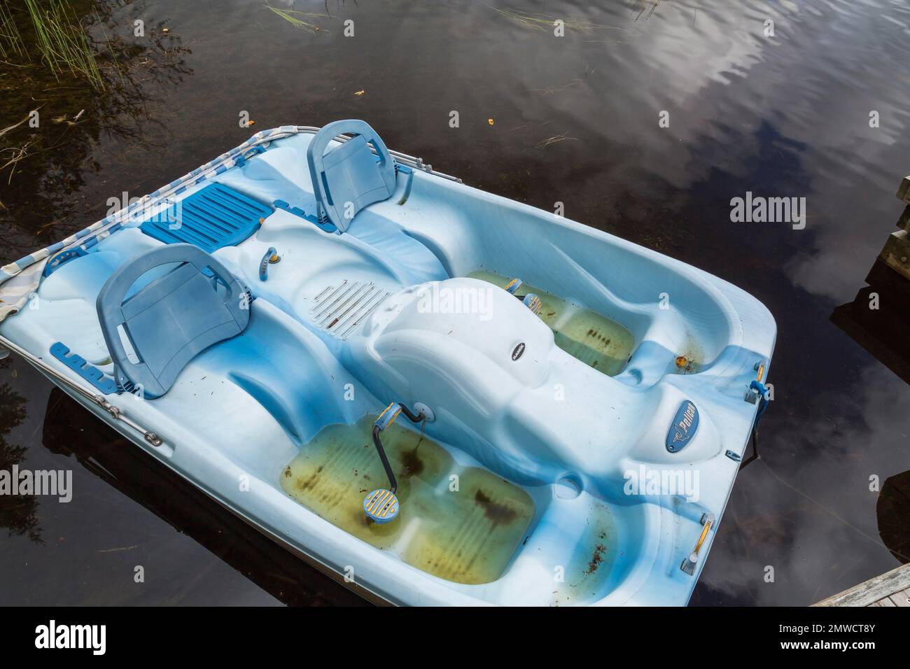 Blue Pelican pedal boat filled with rainwater in summer, Quebec, Canada