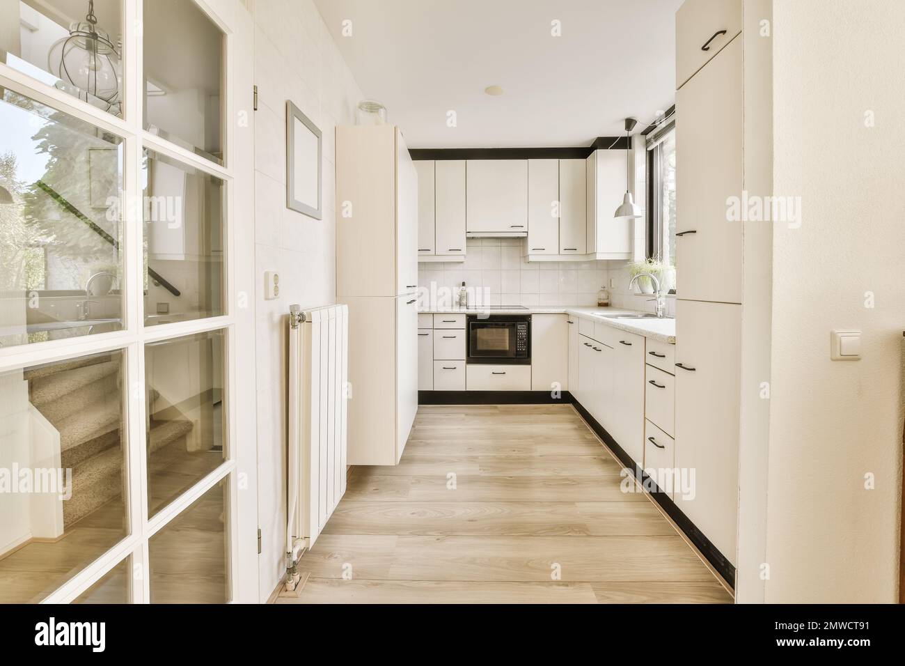 a long narrow kitchen with white cabinets and appliances on the wall ...