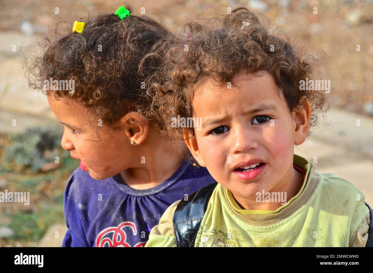 Girl looks sceptically at camera, another looks away, Morocco Stock Photo