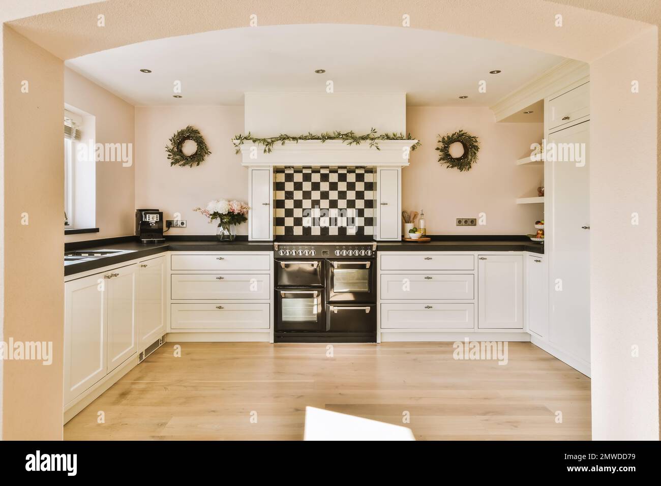 a kitchen with black and white checkered tiles on the walls, wood