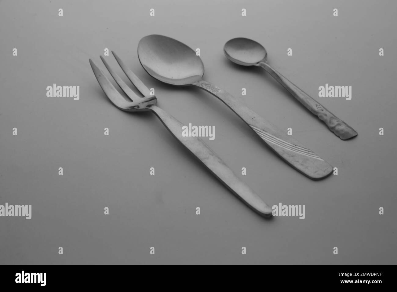 The silver spoon, forks, and knife cutlery isolated on the empty gray