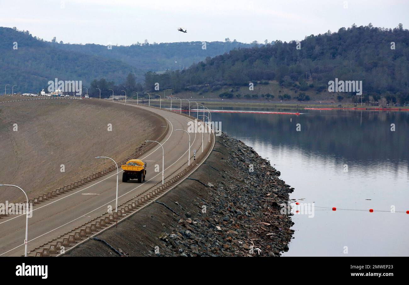 A dump truck carrying a load of rocks crosses the Oroville Dam to be