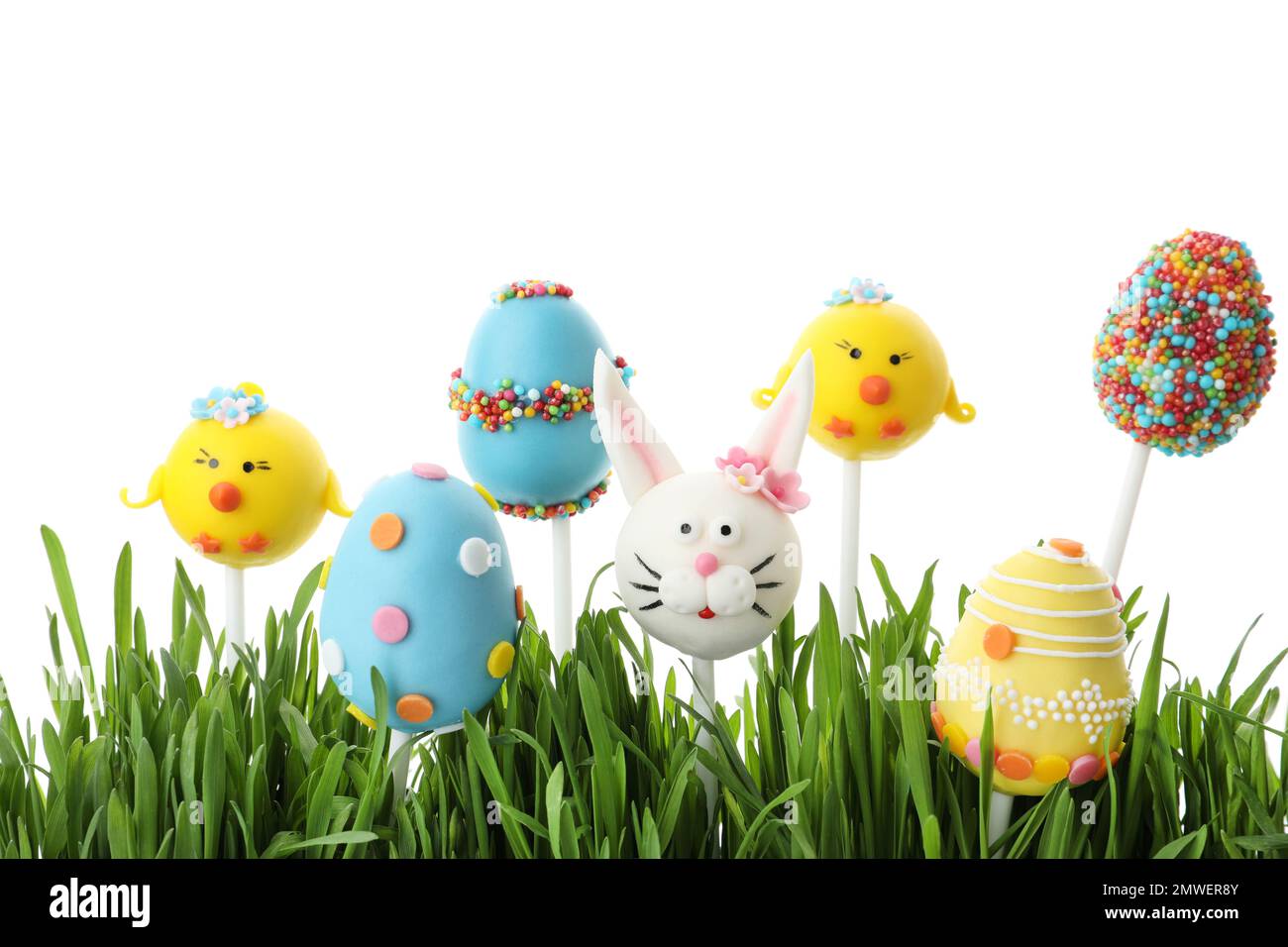 Different sweet cake pops for Easter celebration and grass on white background Stock Photo