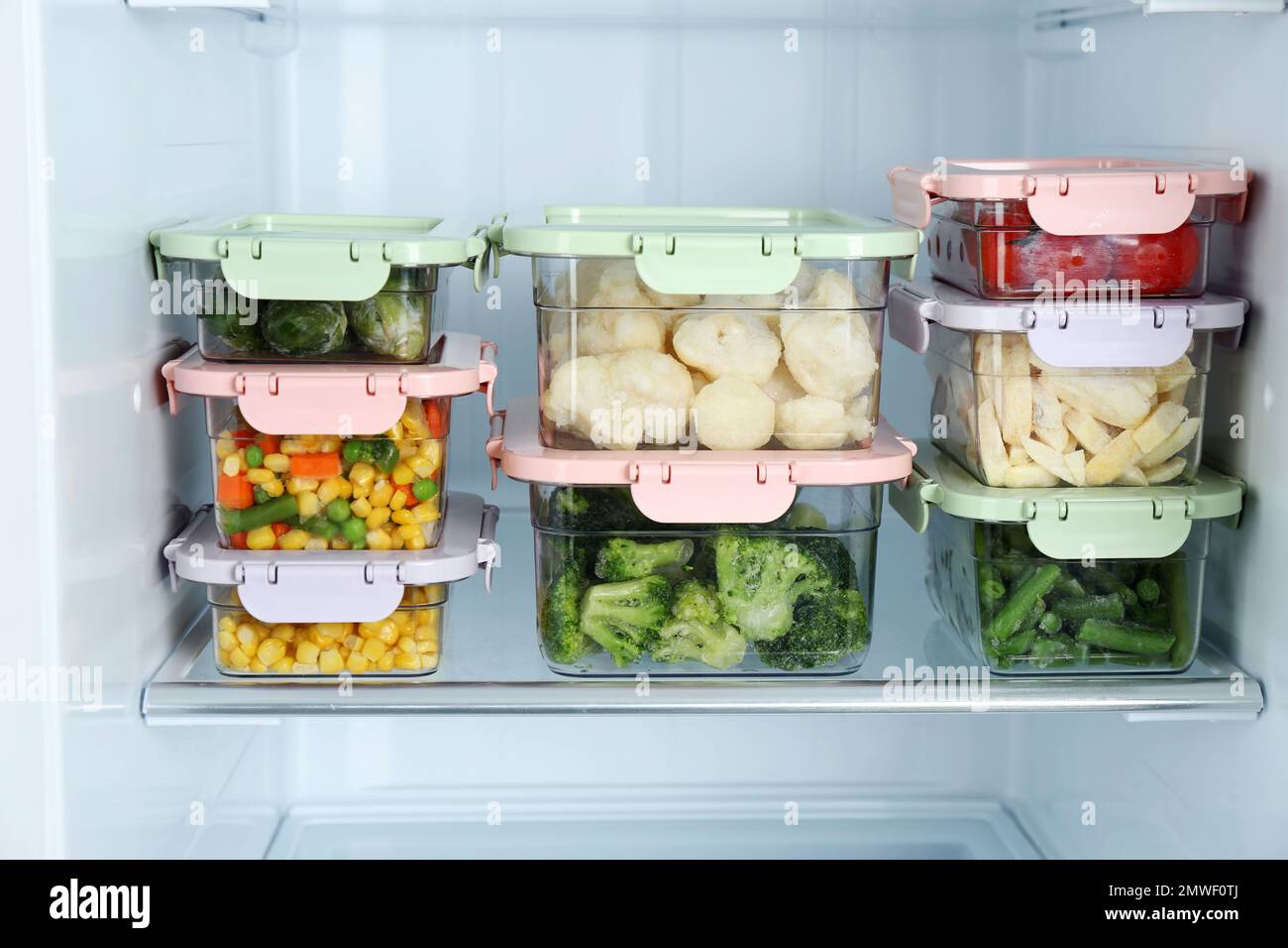 Containers with different frozen vegetables in refrigerator Stock Photo