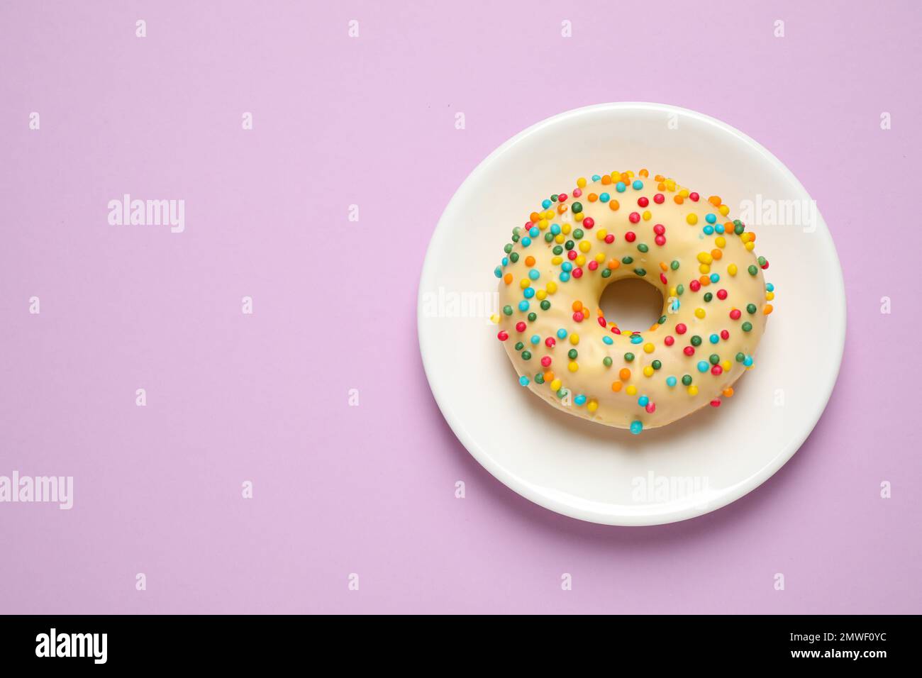 Delicious glazed donut on lilac background, top view. Space for text ...