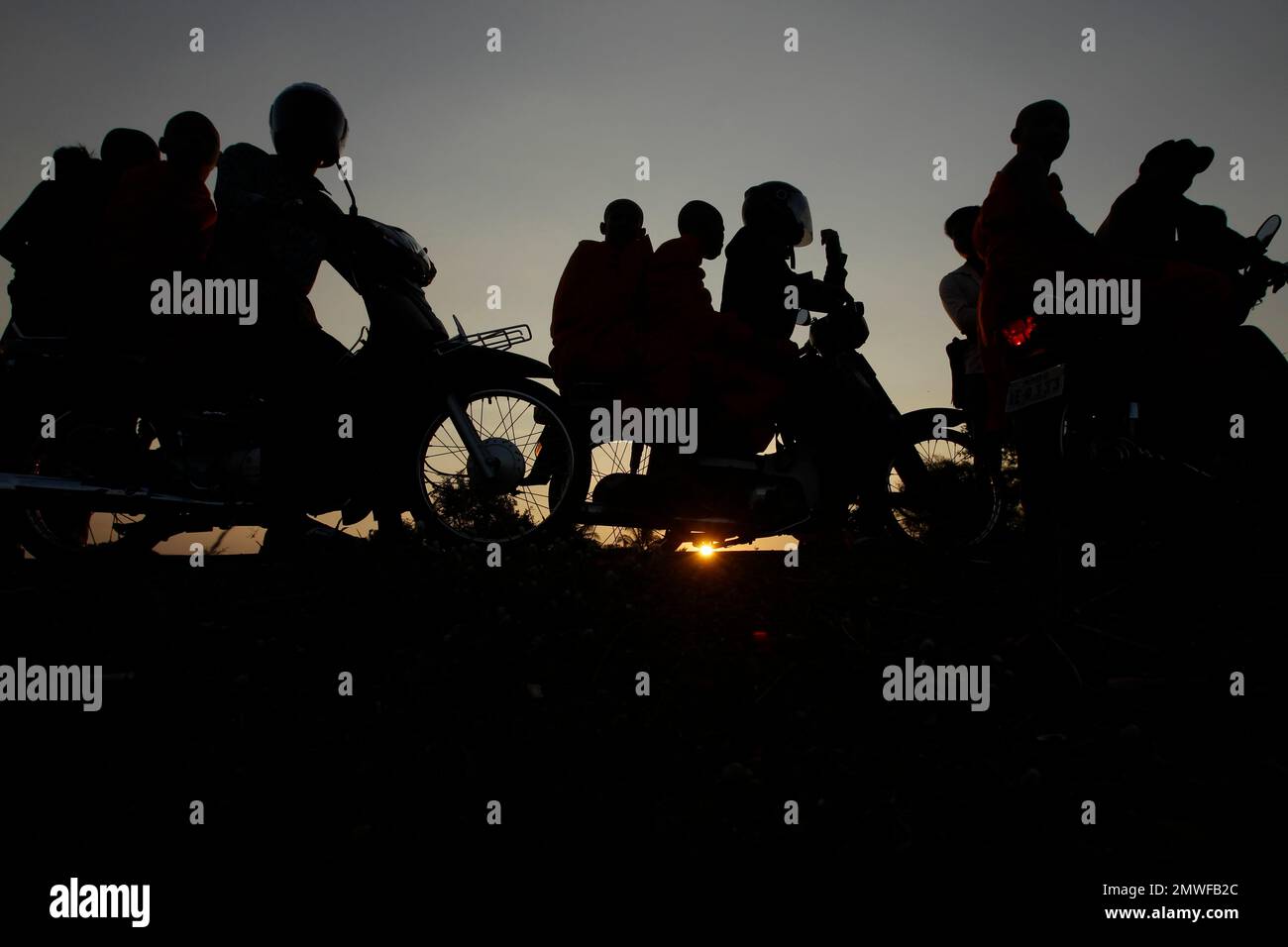Cambodian Buddhist monks in silhouetted as they wait for participating