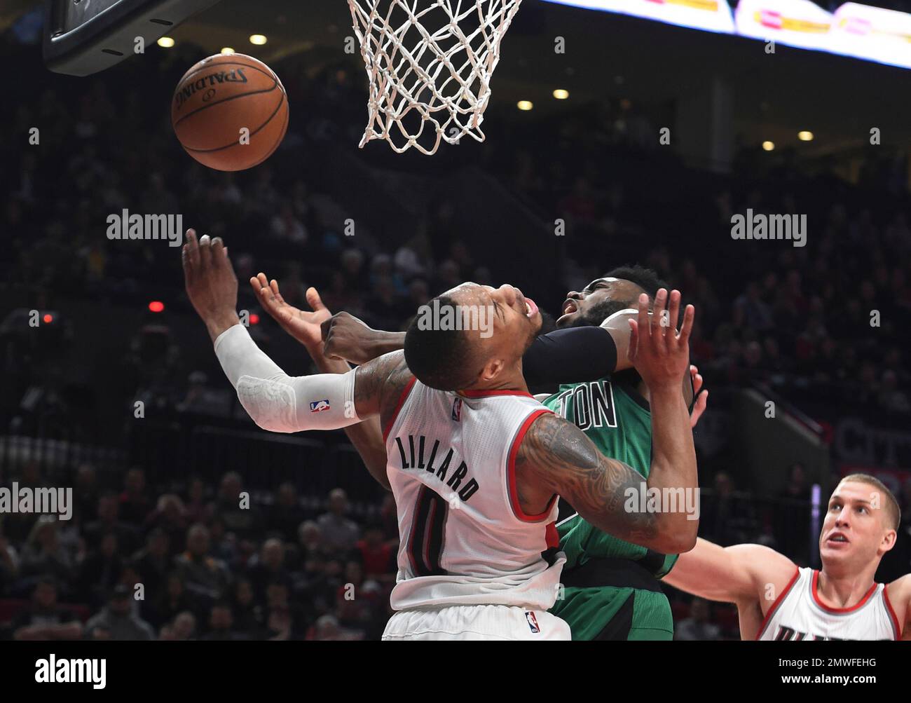 Portland Trail Blazers guard Damian Lillard, left, fouls Boston Celtics