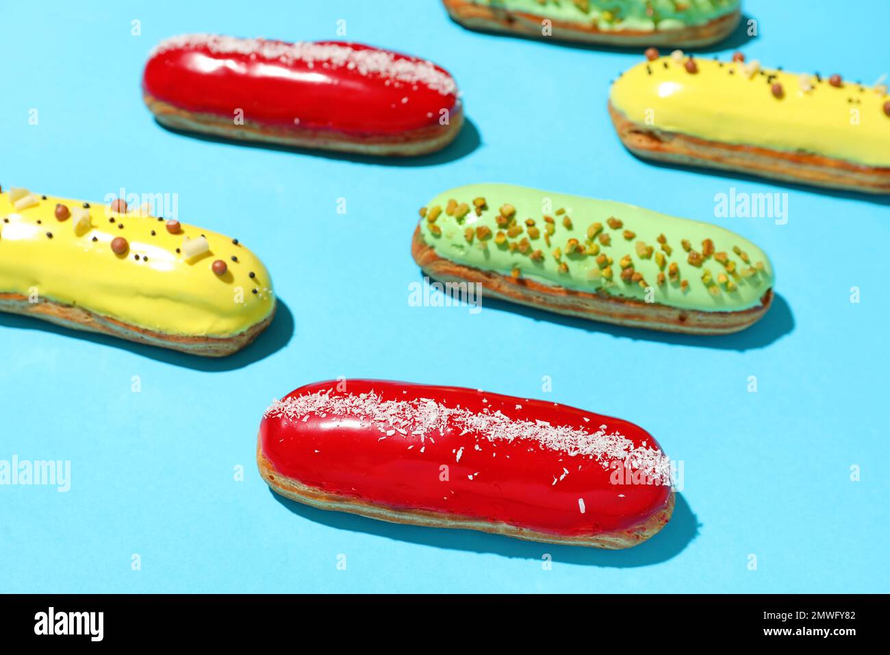 Composition with delicious eclairs on blue background Stock Photo