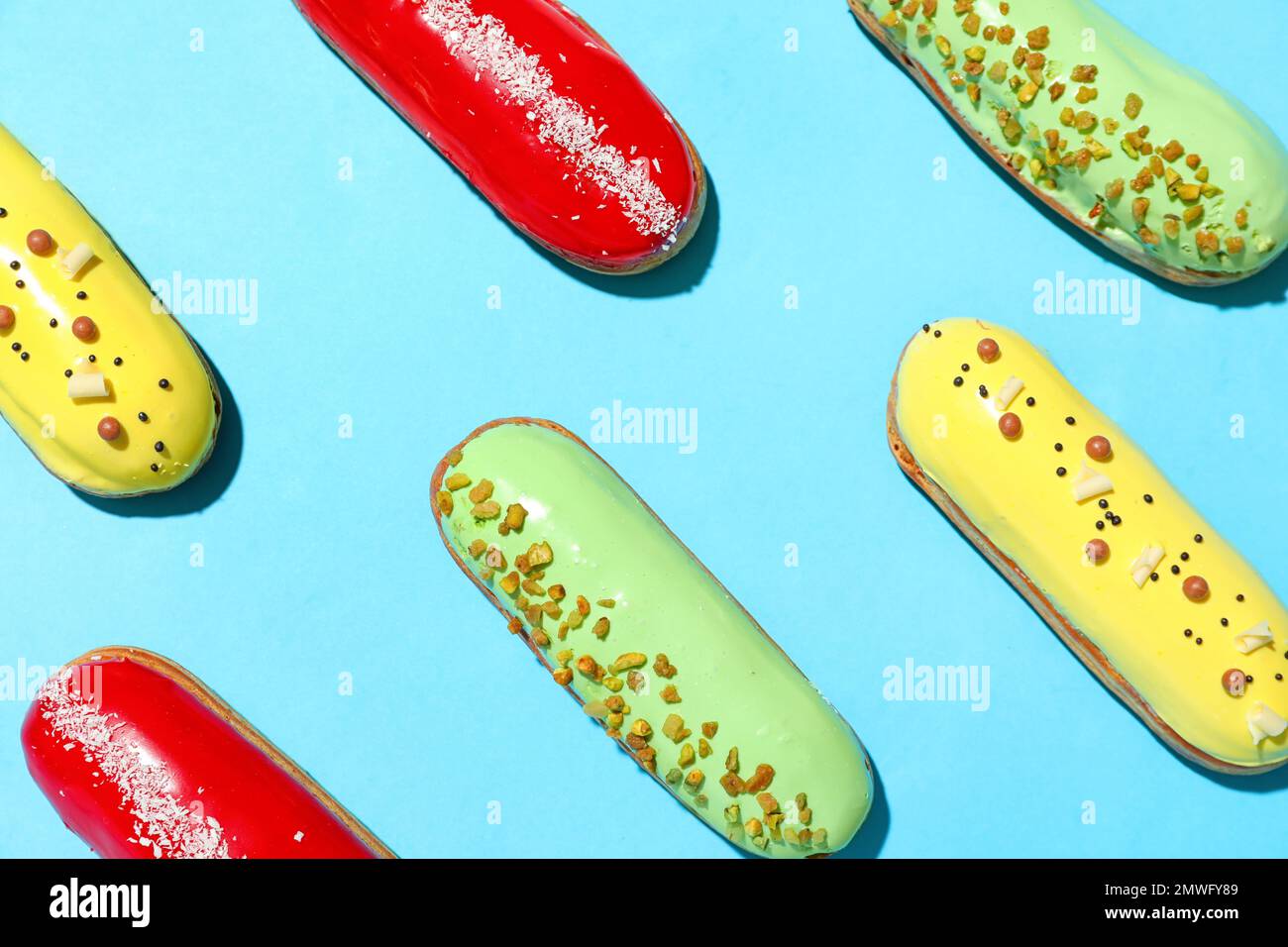 Composition with delicious eclairs on blue background Stock Photo