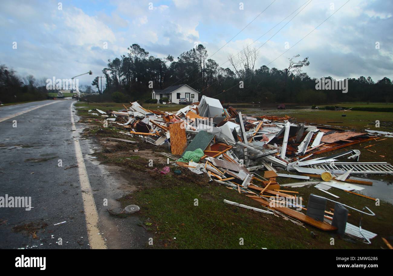The remains of a house sit in a debris pile along Highway 122 as power
