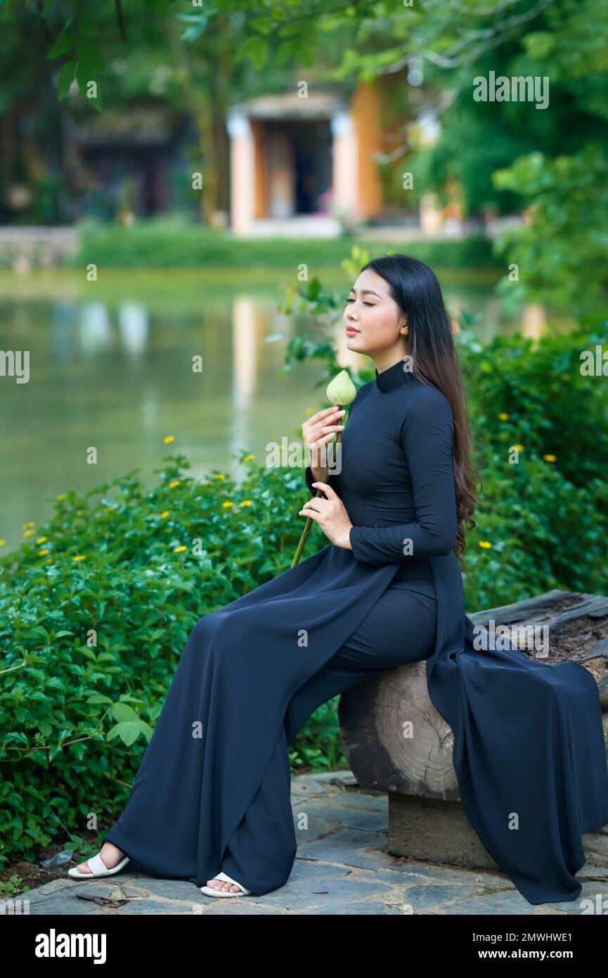 https://c8.alamy.com/comp/2MWHWE1/ho-chi-minh-city-vietnam-ao-dai-is-the-traditional-costume-of-vietnam-beautiful-vietnamese-woman-in-black-ao-dai-in-the-park-2MWHWE1.jpg