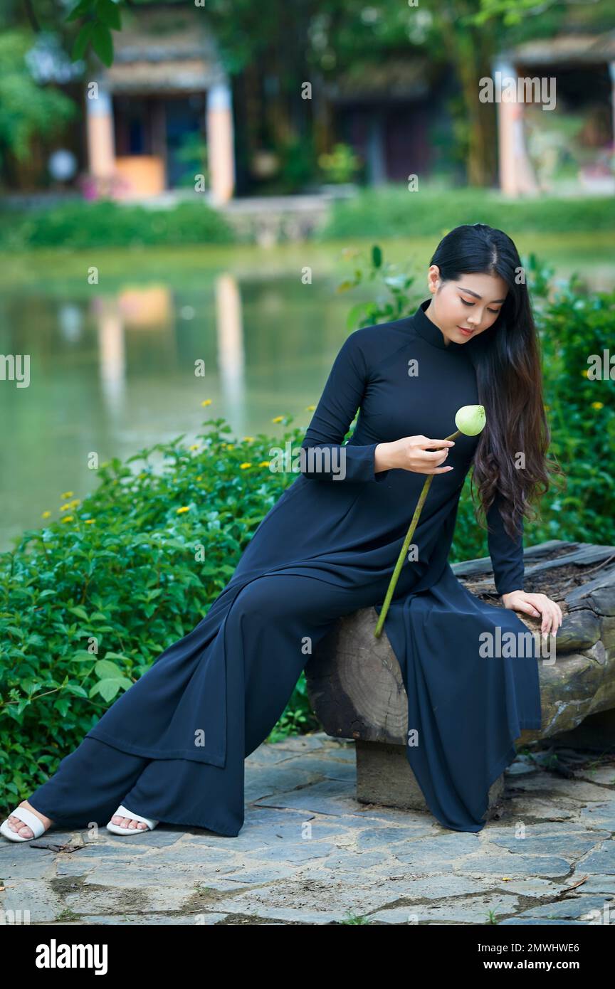 Ho Chi Minh City, Vietnam: Ao Dai is the traditional costume of Vietnam,  beautiful Vietnamese woman in black ao dai in the park Stock Photo - Alamy