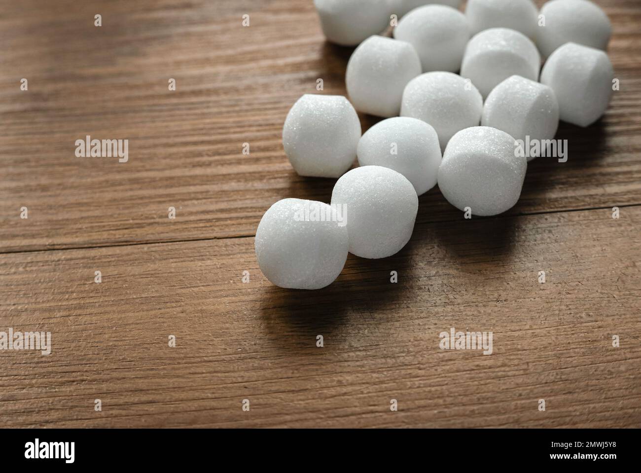 https://c8.alamy.com/comp/2MWJ5Y8/naphthalene-mothballs-on-wooden-background-2MWJ5Y8.jpg