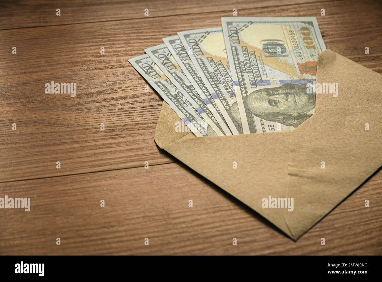 A money inside an envelope.Bonus, reward, income, benefit or bribery concept. Stock Photo