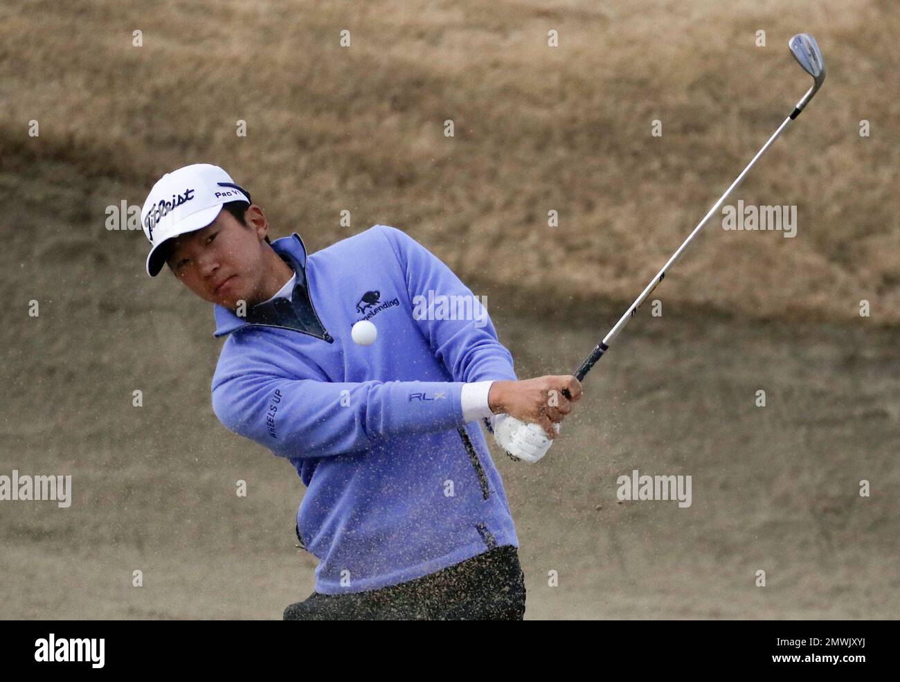 Michael Kim hits from the bunker on the 11th hole during the second