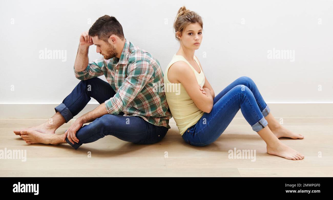 Arguments are inevitable in a marriage. a young couple having relationship difficulties sitting back to back. Stock Photo