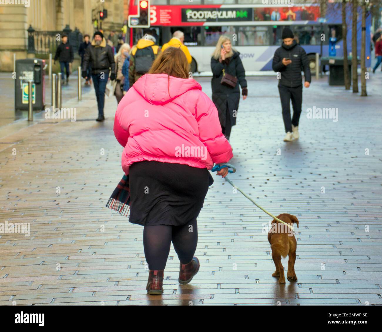 large girl walking small dog om Buchanan street Glasgow, Scotland, UK Stock Photo