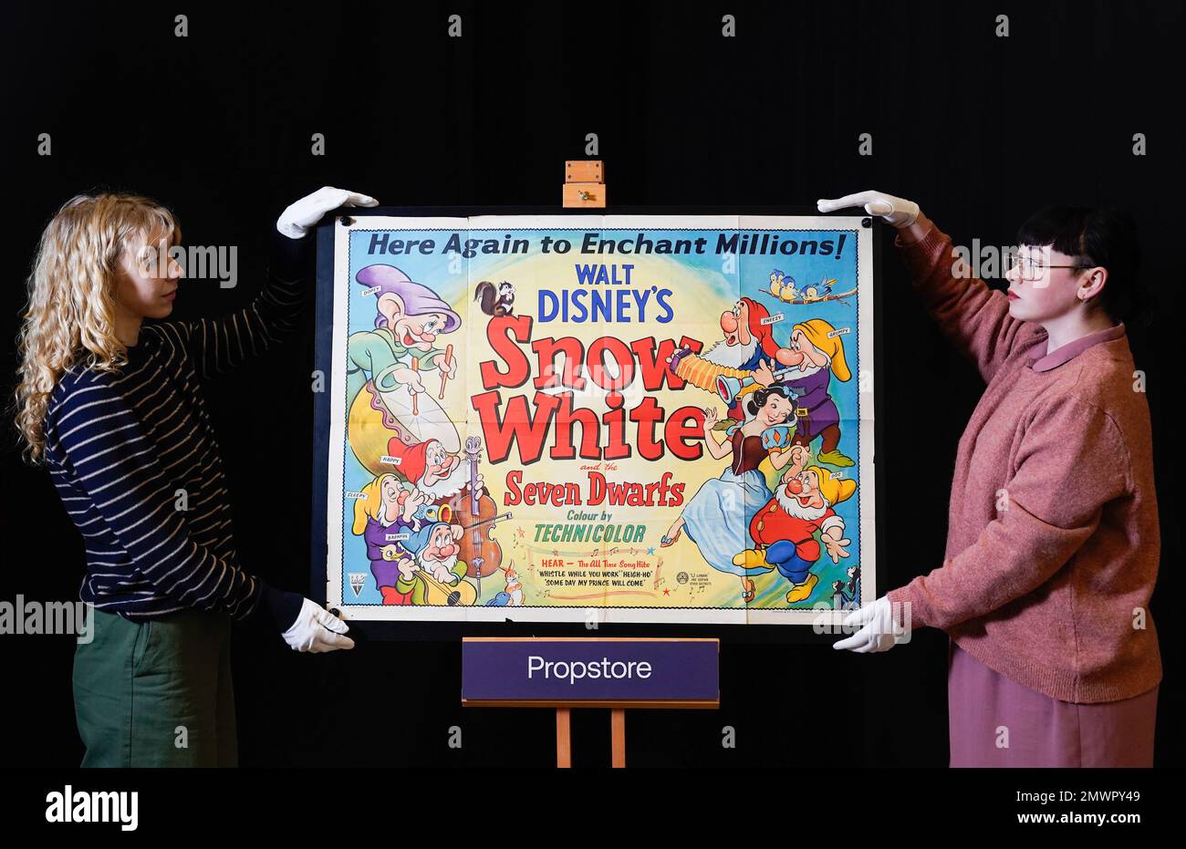 Propstore employees adjust a 1944 UK quad poster for the 1937 film 'Snow White and the Seven Dwarfs' (Estimate £ 2000 - 4000) during a preview for the showbiz memorabilia auction, at the Propstore in Rickmansworth, Hertfordshire. Picture date: Thursday January 19, 2023. Stock Photo