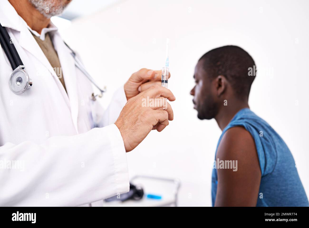This wont hurt a bit. a male doctor preparing a syringe before giving