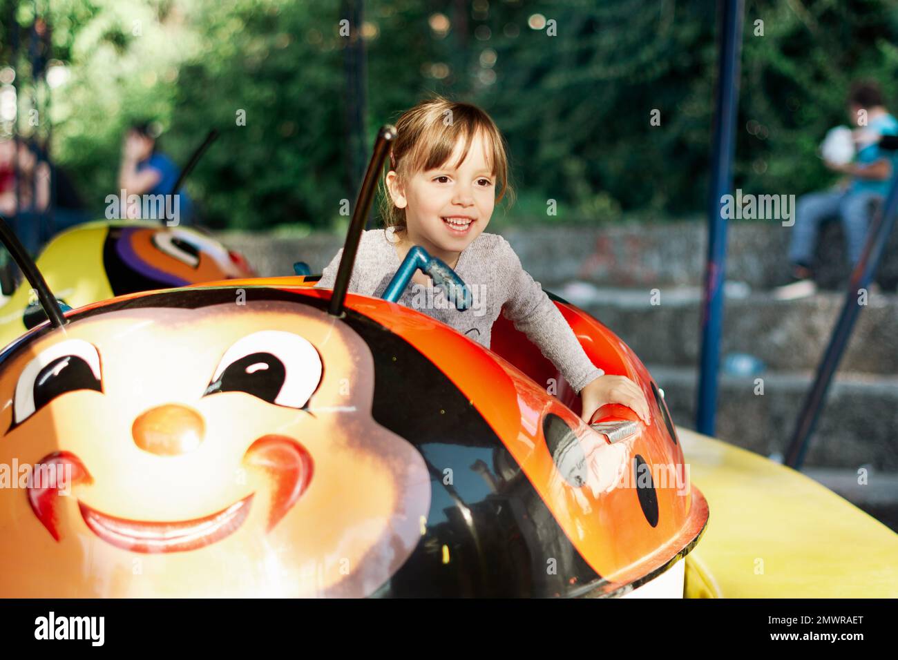 Happy child girl riding train on funfair on summer vacation Stock Photo ...