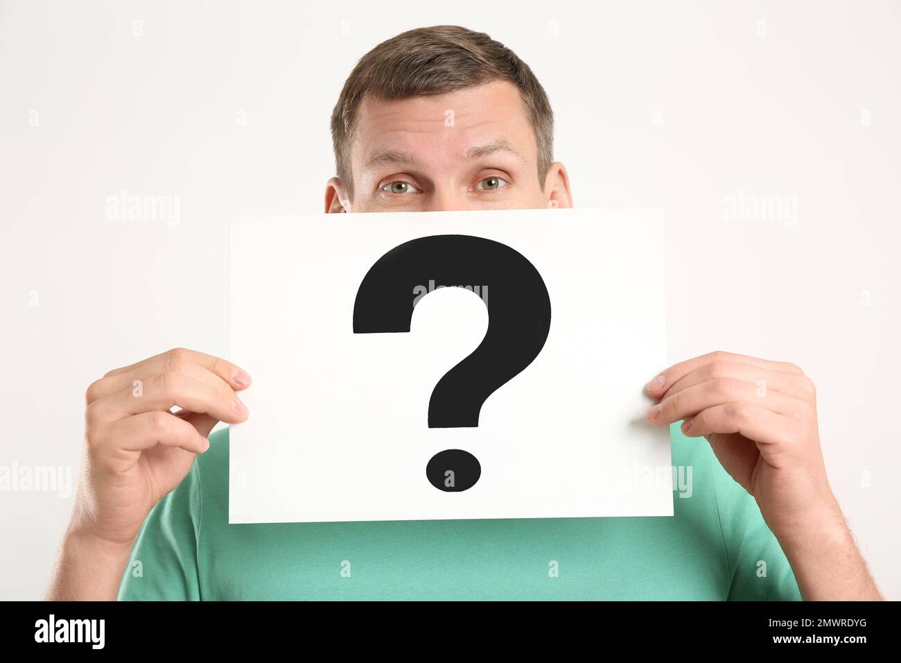 Man holding paper with question mark on white background Stock Photo ...