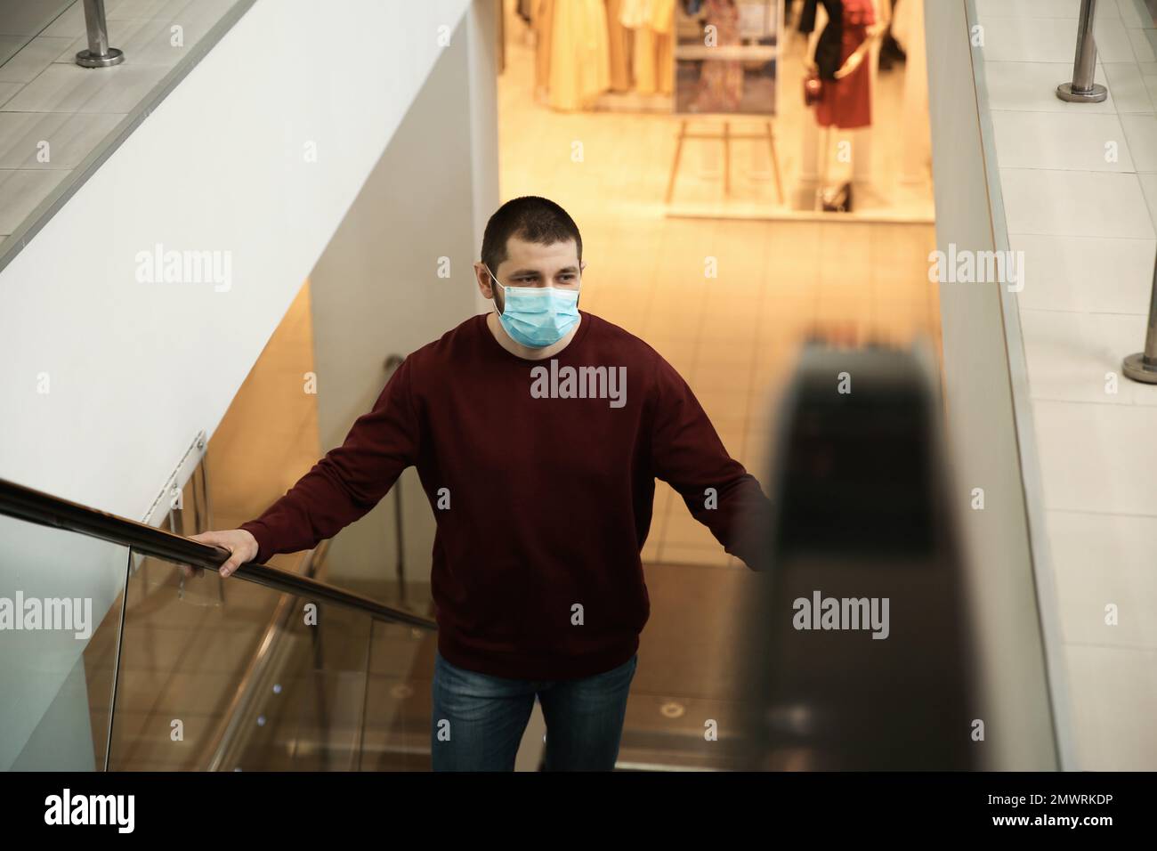 Man with disposable mask on escalator in mall. Dangerous virus Stock ...