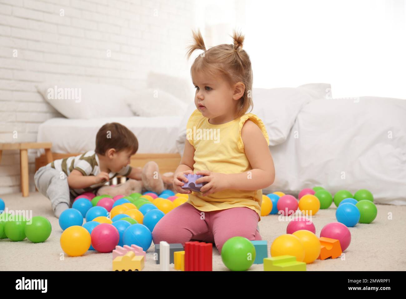 Cute little children playing with toys on floor at home Stock Photo - Alamy