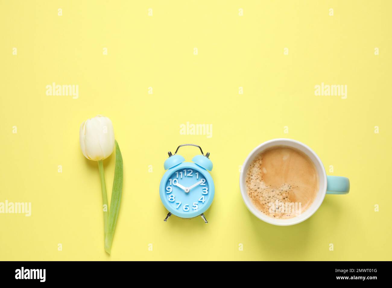 https://c8.alamy.com/comp/2MWT01G/white-tulip-alarm-clock-and-coffee-on-yellow-background-flat-lay-with-space-for-text-good-morning-2MWT01G.jpg