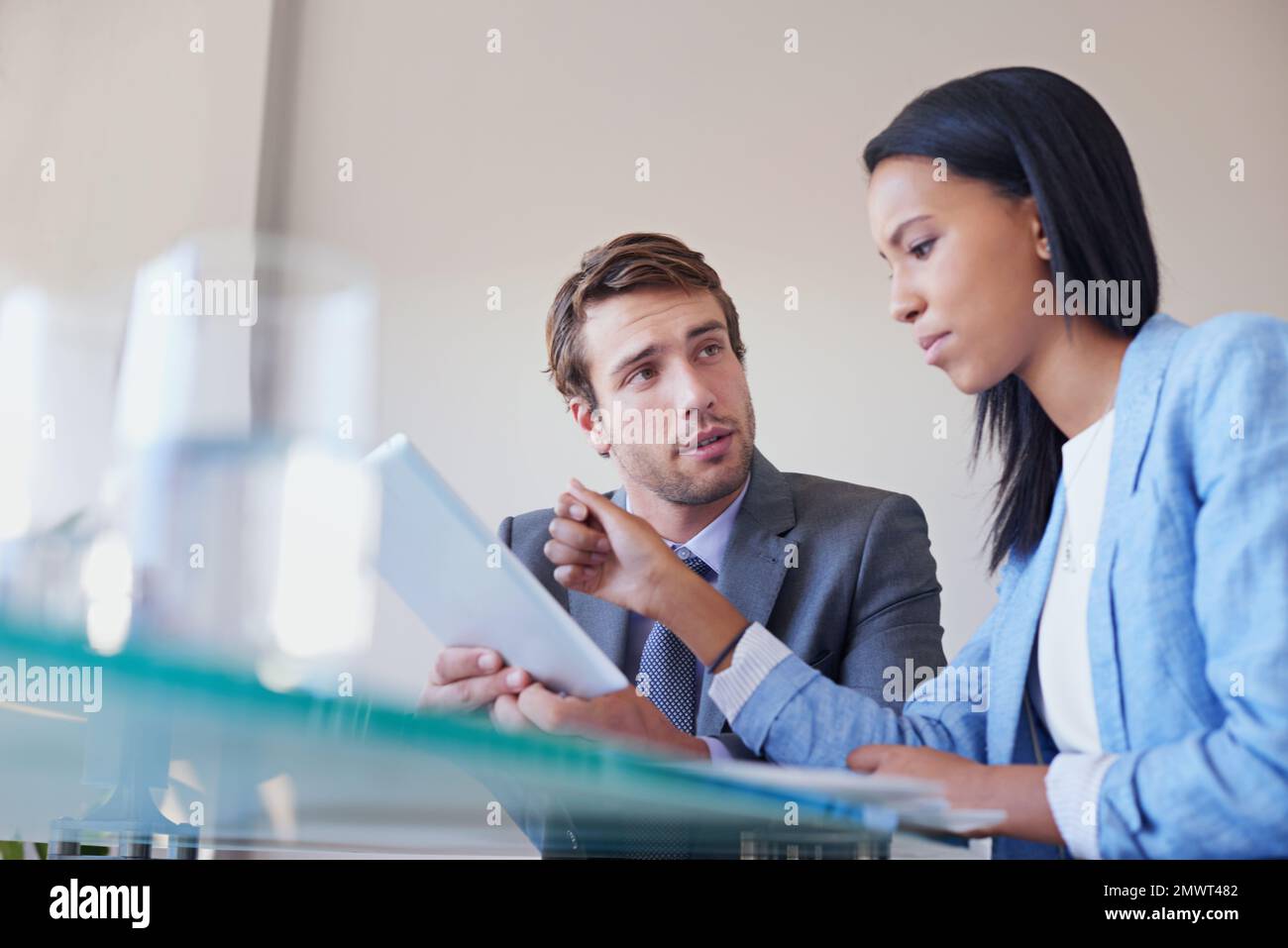 Business strategizing aided by technology. two business executives discussing work on a digital tablet. Stock Photo