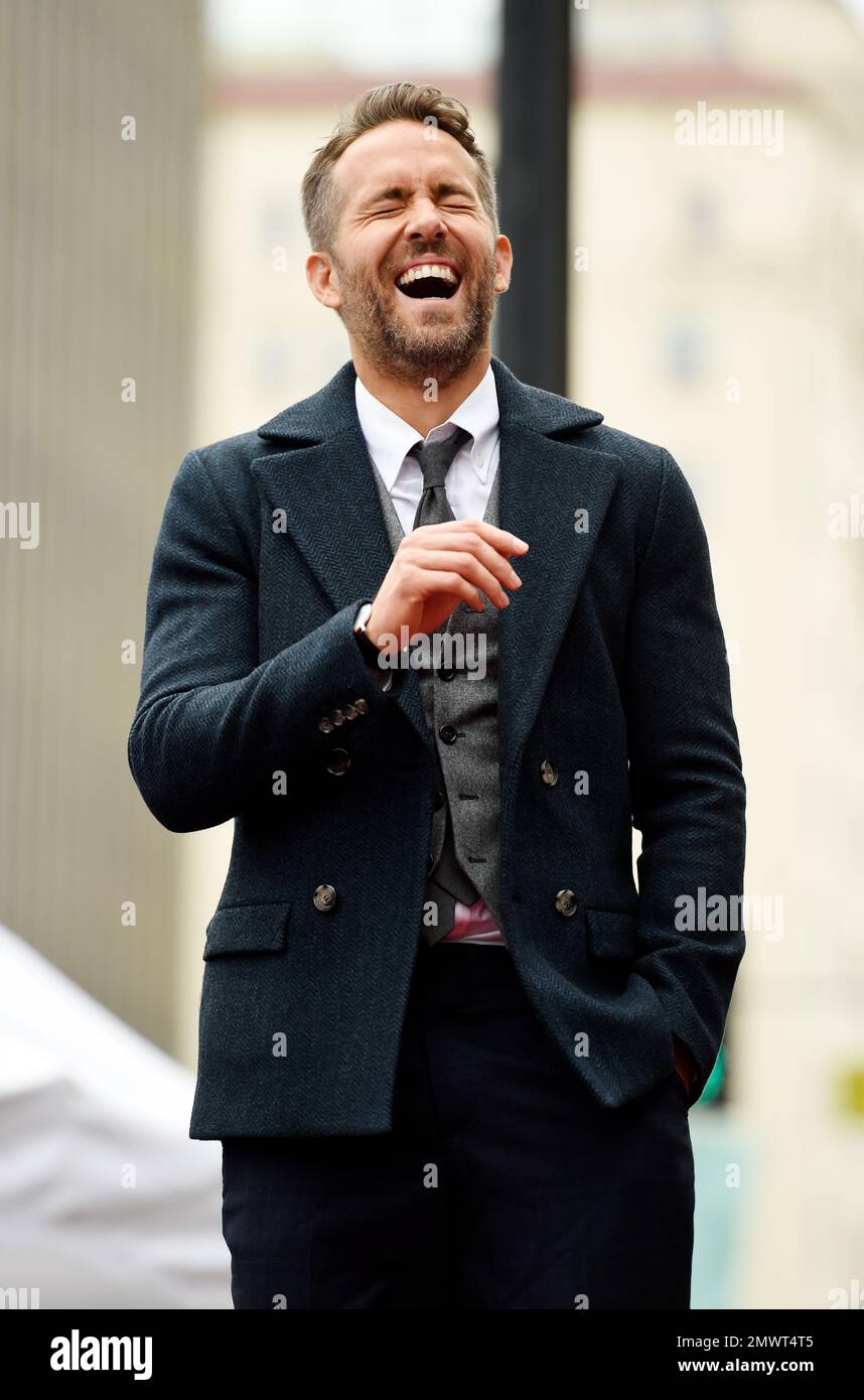 Actor Ryan Reynolds laughs during actress Anna Faris' speech during a