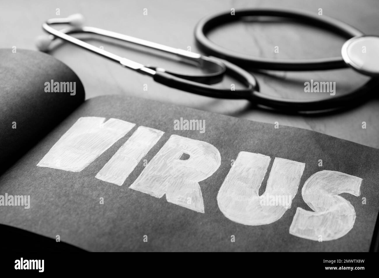 Notepad with word VIRUS and stethoscope on black background, closeup Stock Photo