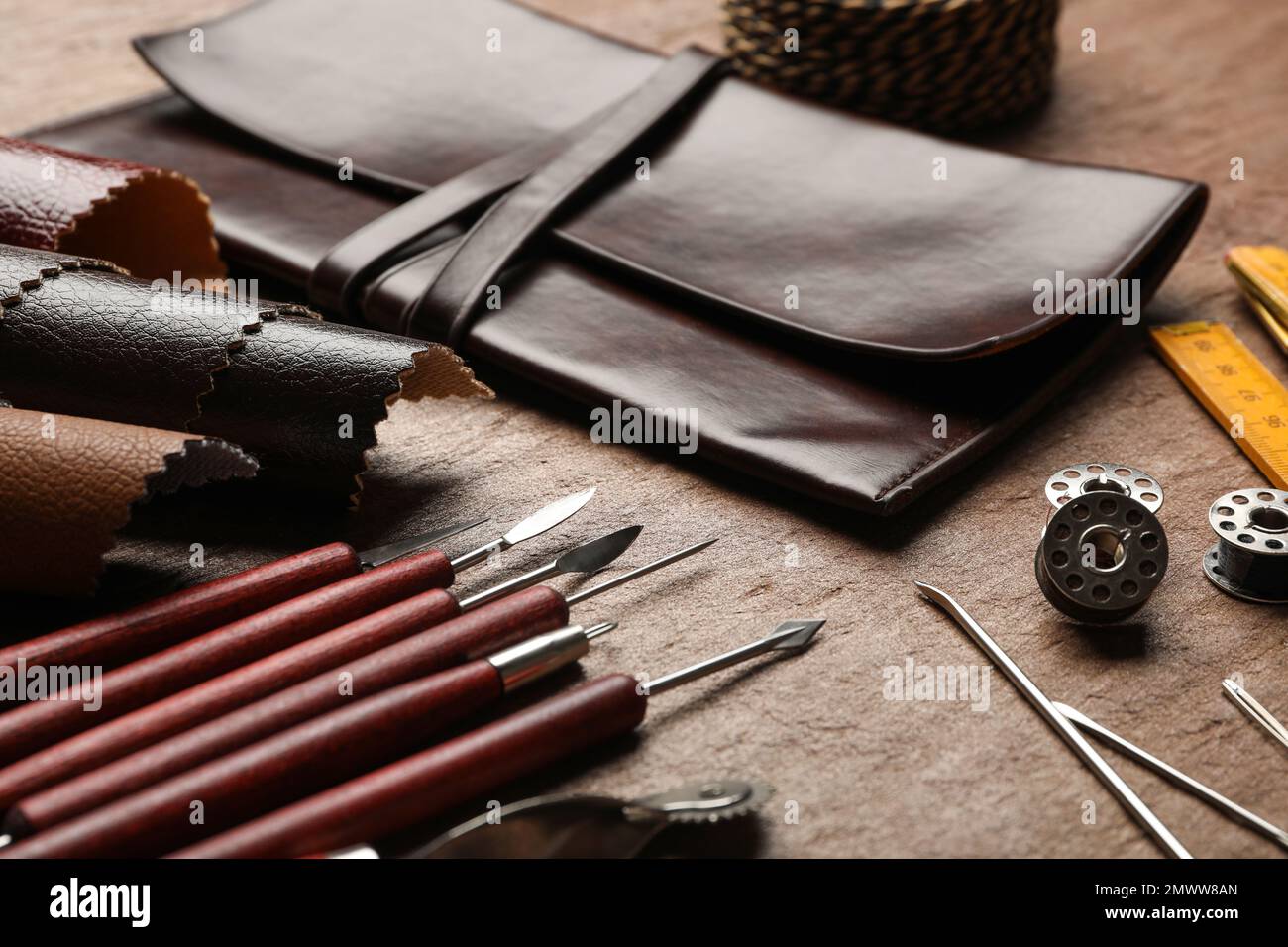 Leather samples and tools on brown table, closeup Stock Photo