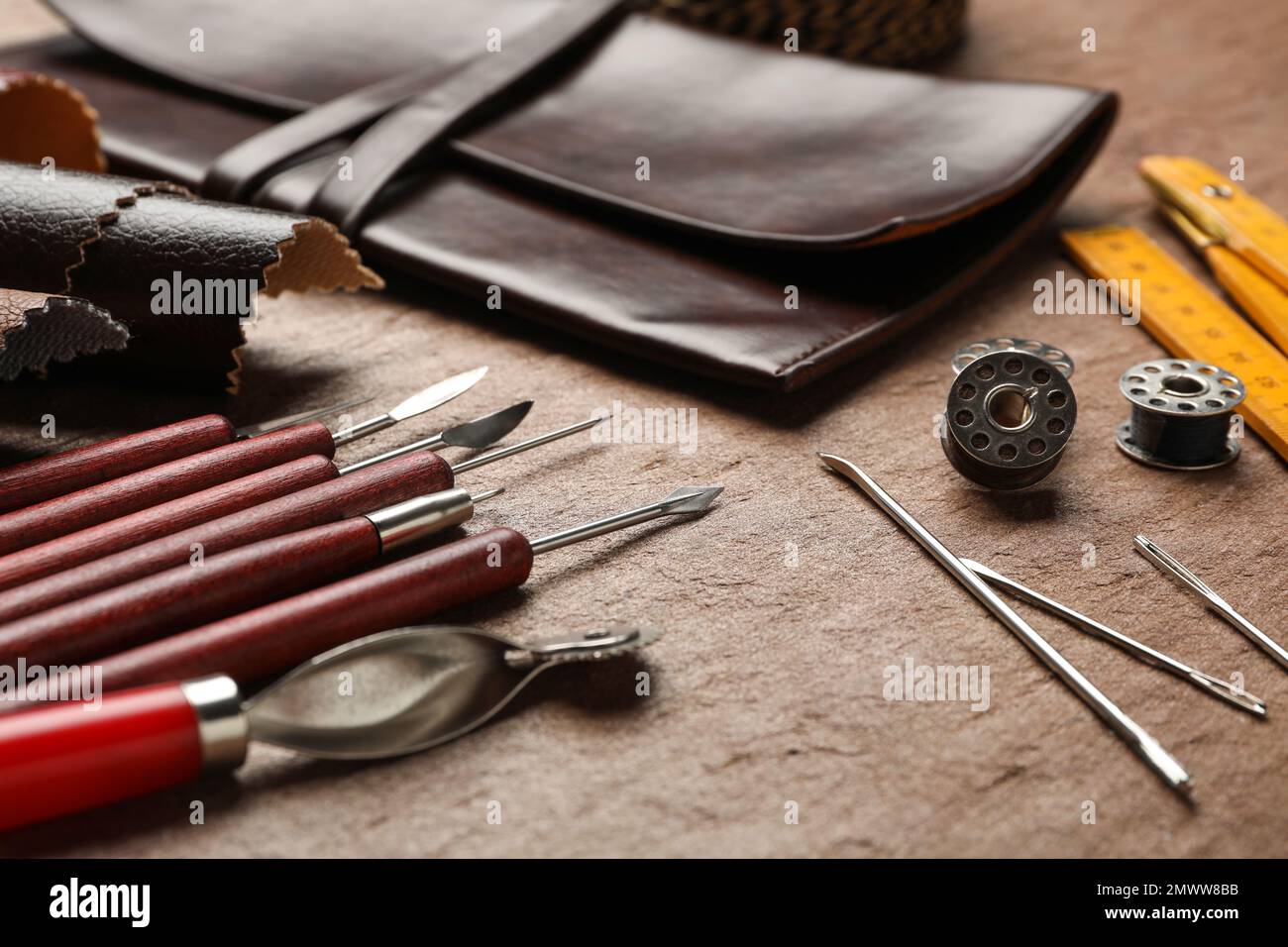 Leather samples and tools on brown table, closeup Stock Photo