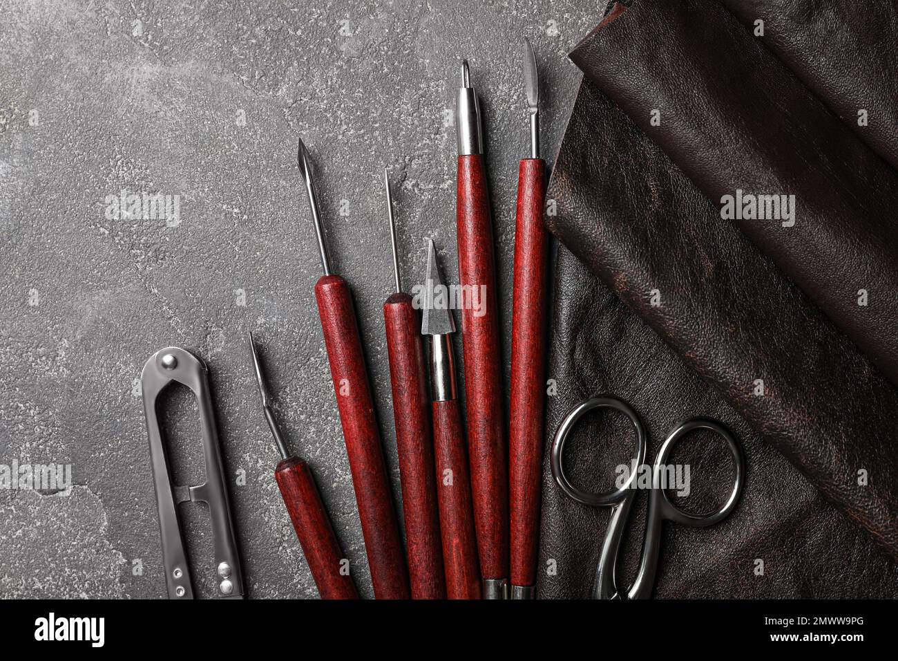 Leather sample and craftsman tools on grey stone background, flat lay ...