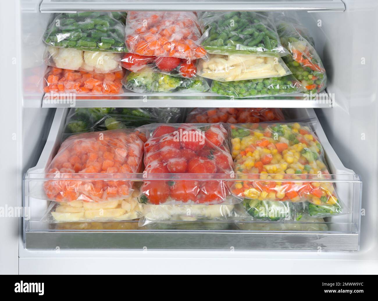 Plastic bags with different frozen vegetables in refrigerator Stock Photo Alamy