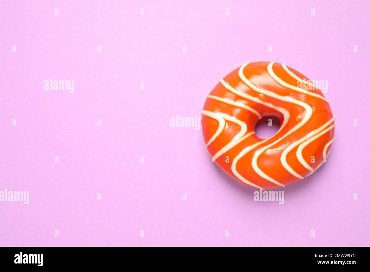 Delicious glazed donut on lilac background, top view. Space for text ...