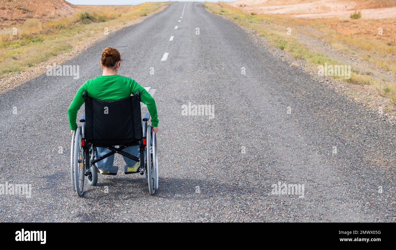 Woman in a wheelchair on a highway in the steppes Stock Photo Alamy