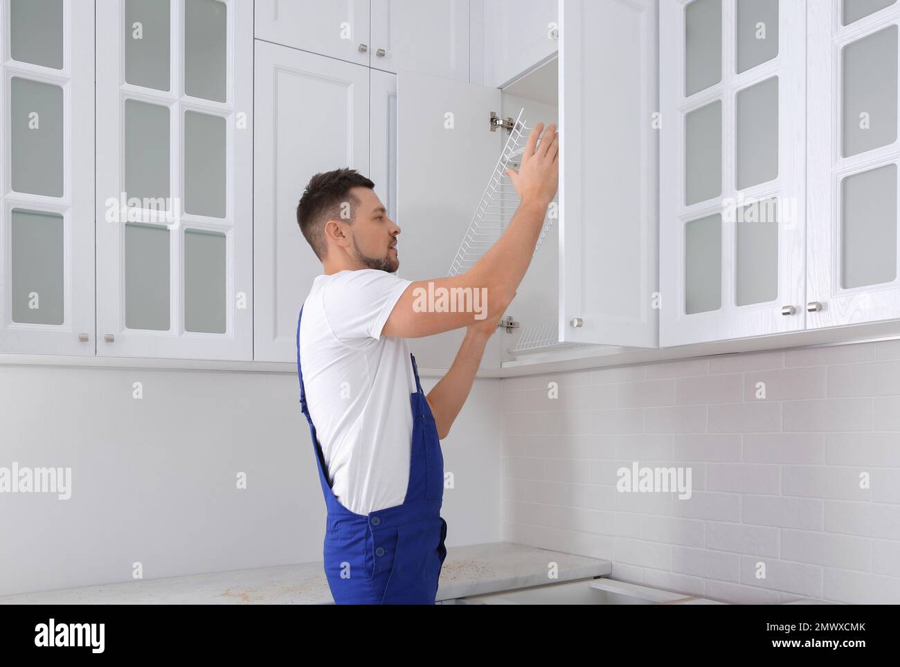 Worker installing with shelves in kitchen Stock Photo Alamy
