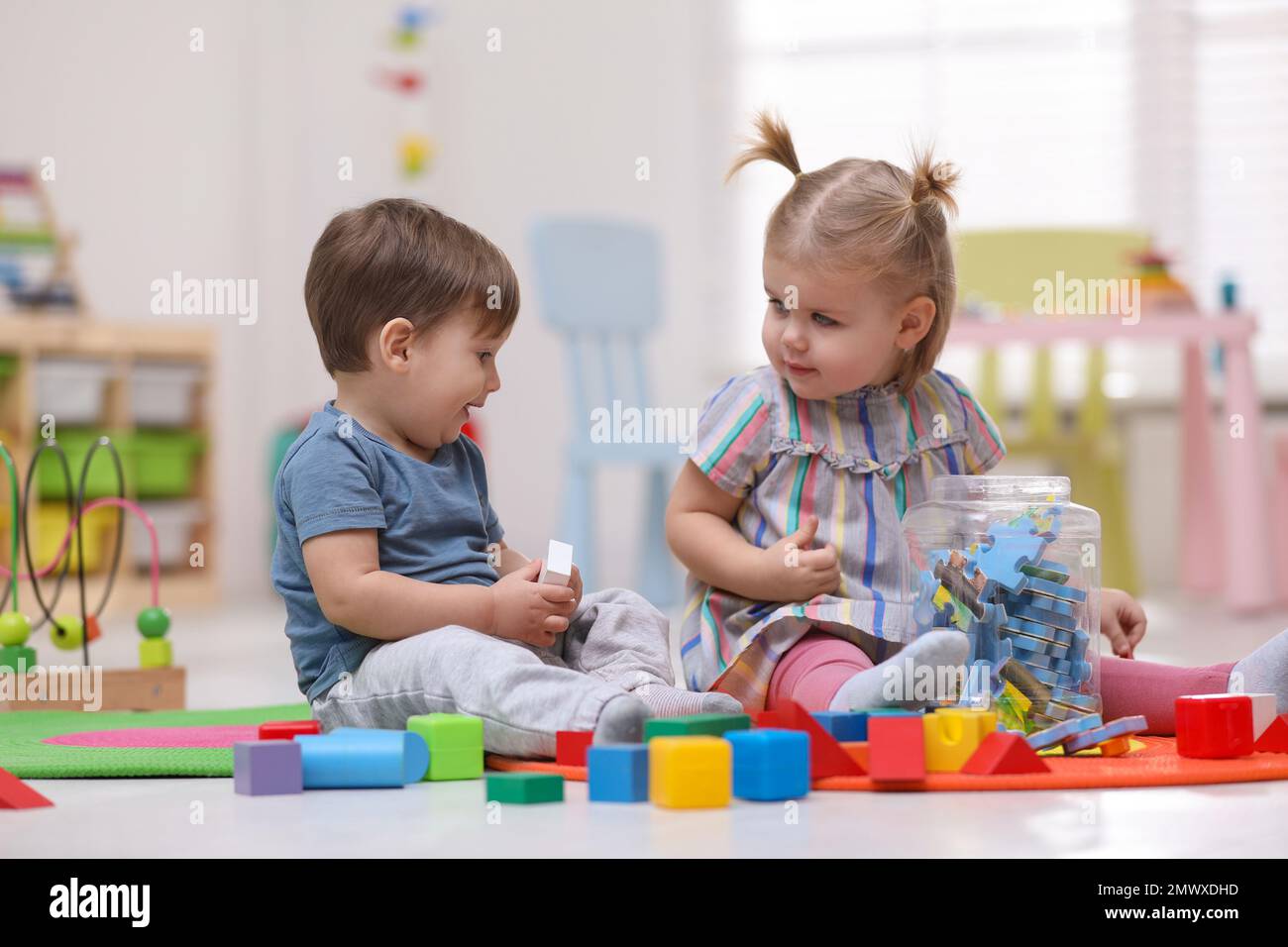 Cute little children playing together on floor at home Stock Photo - Alamy