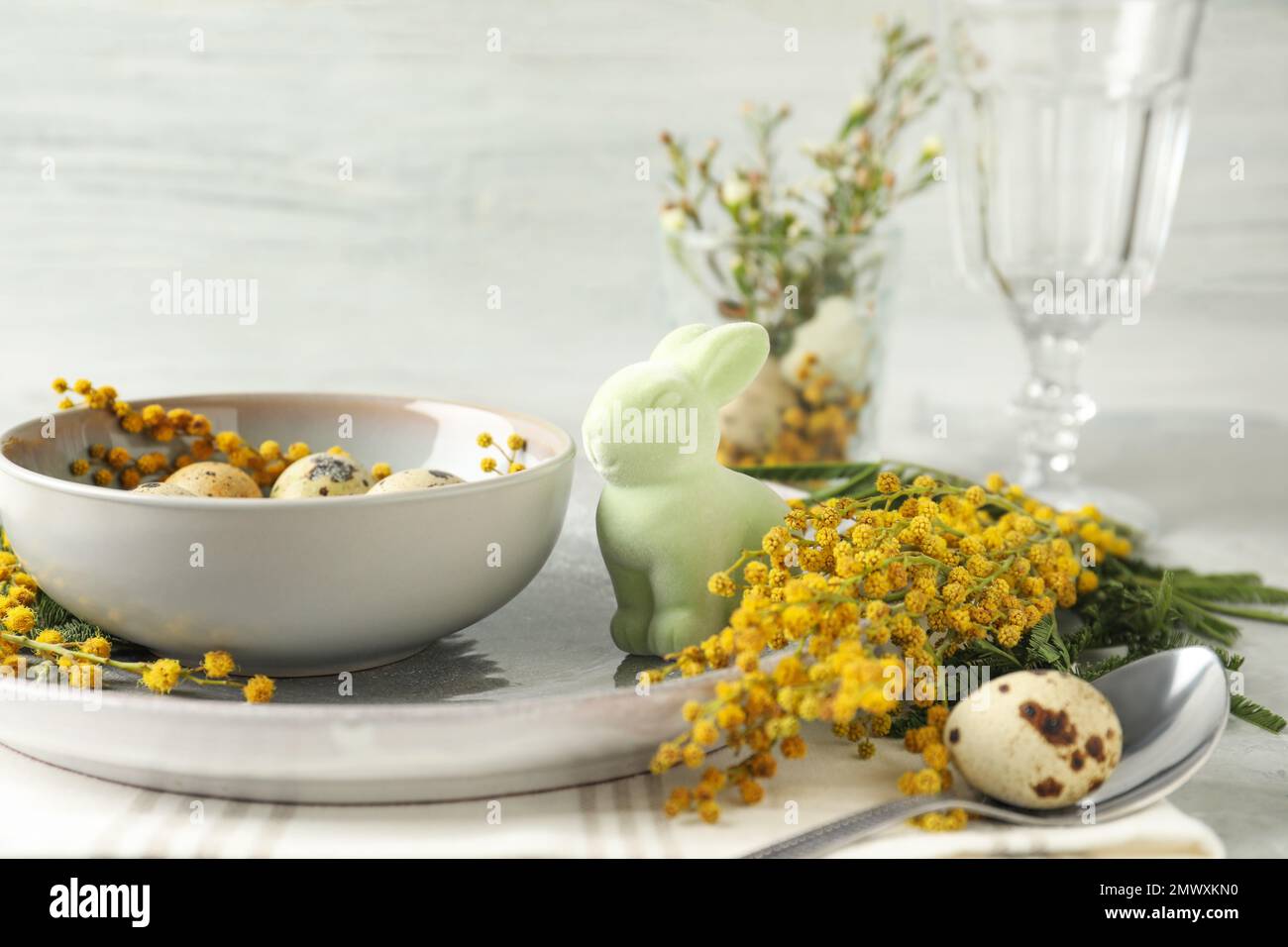 Festive Easter table setting with beautiful mimosa flowers Stock Photo