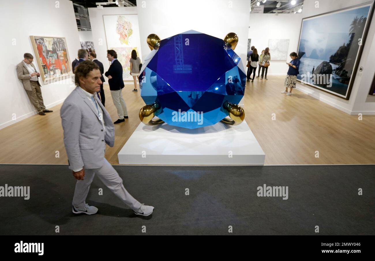 A guest walks by the sculpture, Diamond (Blue) by artist Jeff Koon at