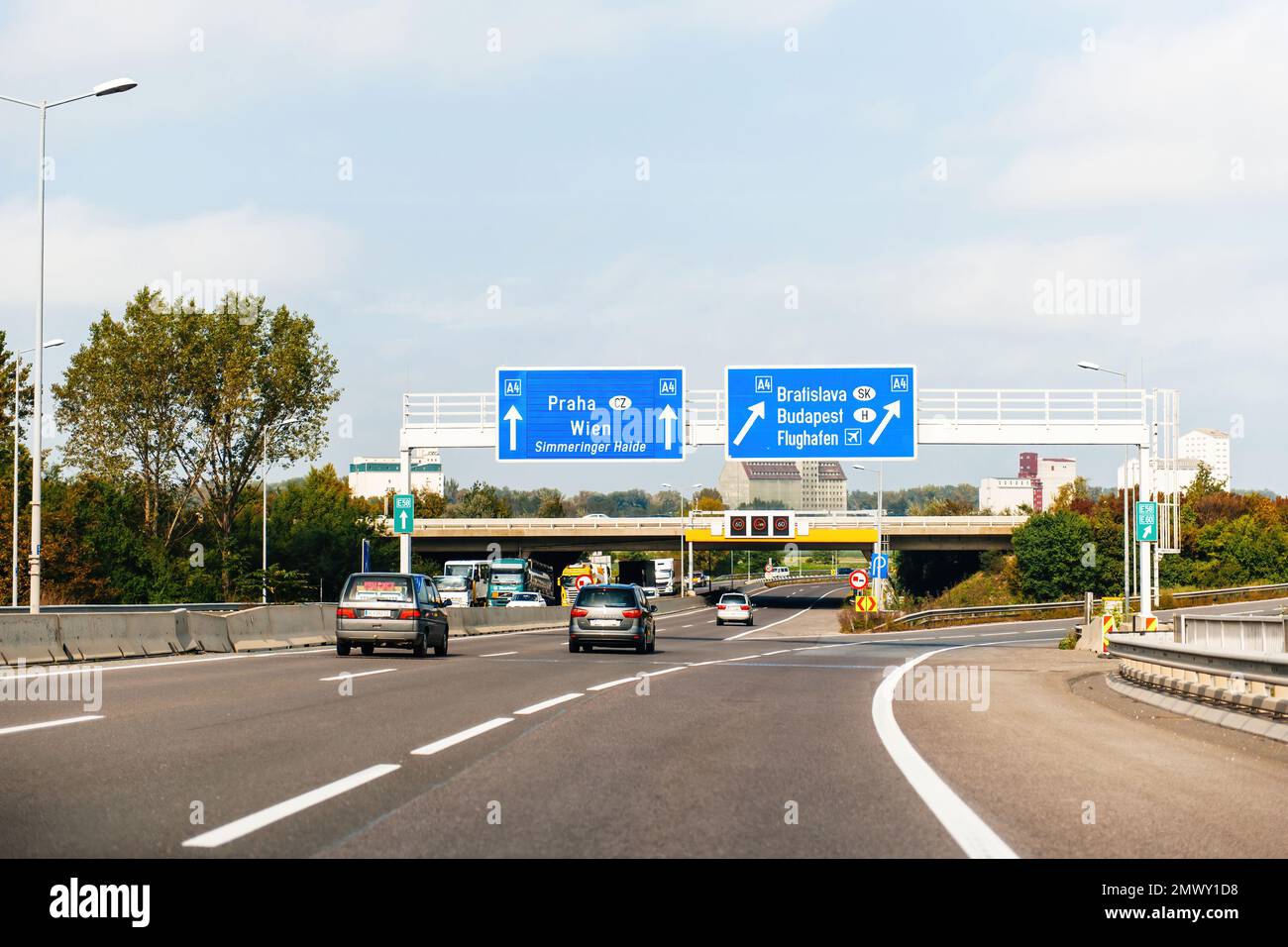 Austria - Sep 30, 2014: View from the highway at the blue direction signs above with Praha, Wien, Simmeringer haide, Bratislava, Budapest and Airport Flughafen A4 - driving in Austria near the border Stock Photo