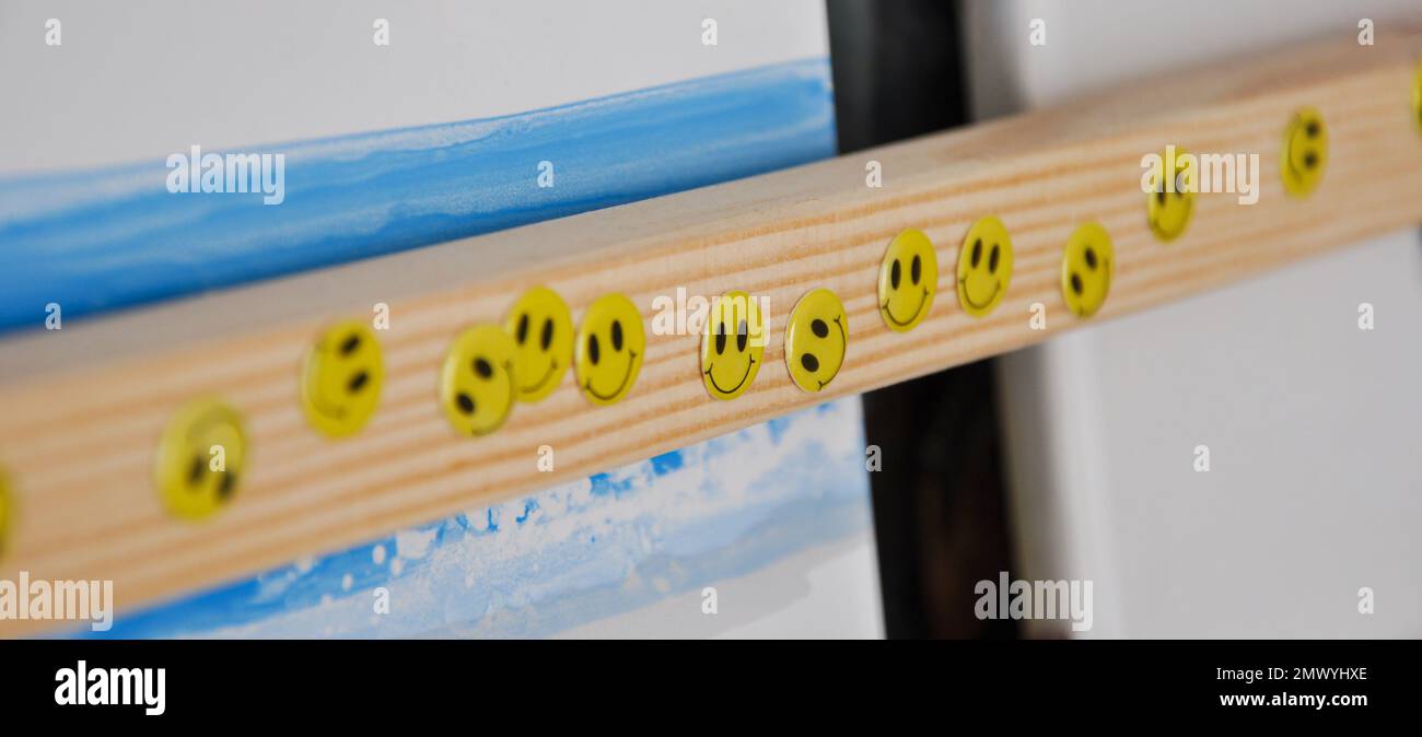 Smiley face stickers on a wooden bookcase, toddler room, happy stickers Stock Photo