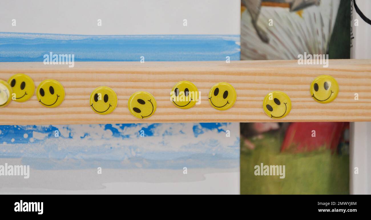 Smiley face stickers on a wooden bookcase, toddler room, happy stickers Stock Photo