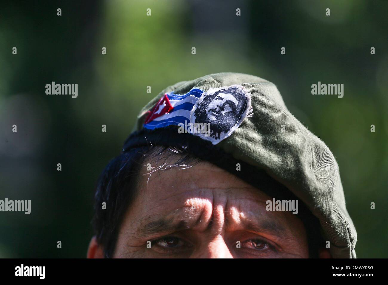 A man wearing a beret decorated with a Cuban flag and image of Cuba's  revolutionary hero Ernesto Che Guevara, gathers with others outside  Cuba's embassy in Santiago, Chile, Saturday, Nov. 26, 2016
