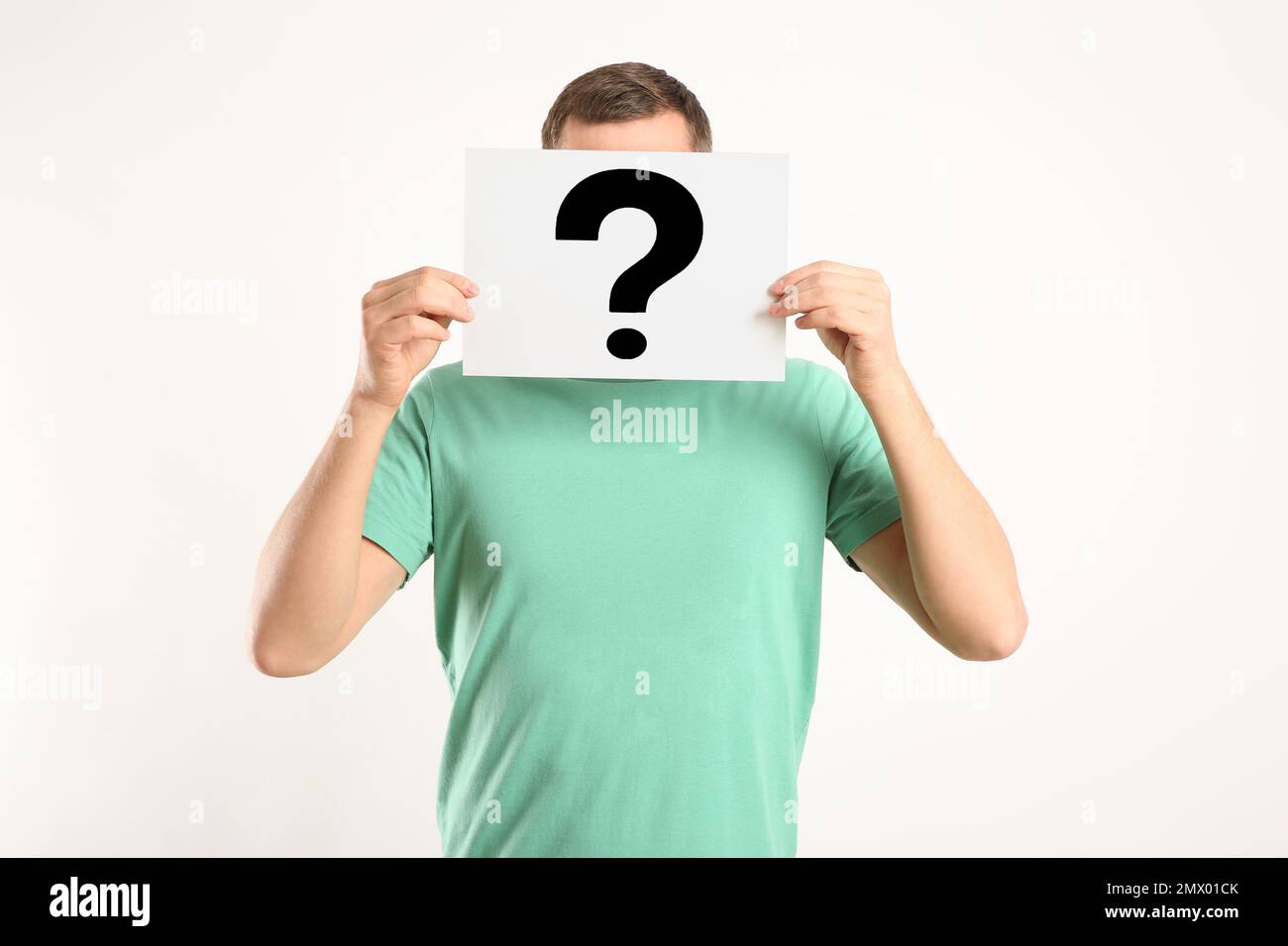 Man holding paper with question mark on white background Stock Photo ...